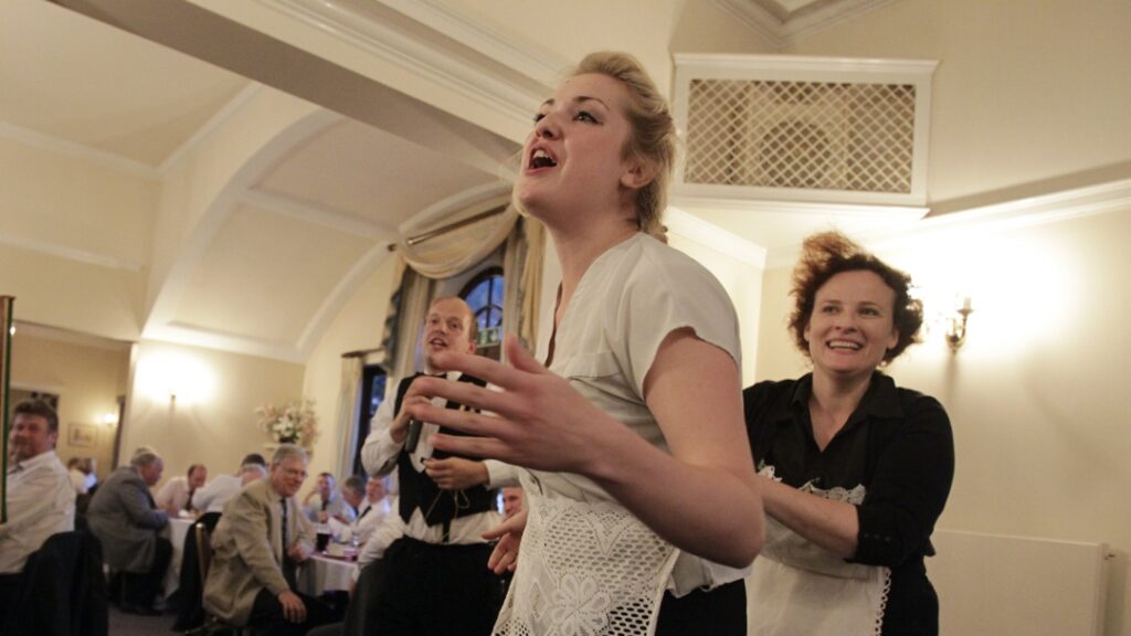 A waiter sings at dinner party