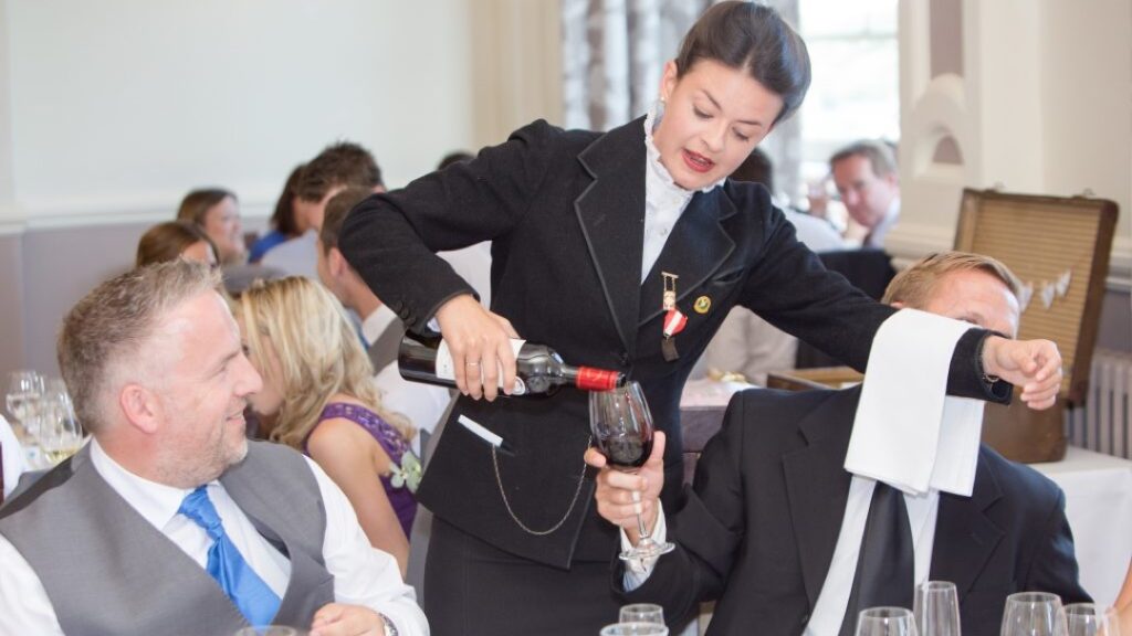 waiter serves vine at wedding